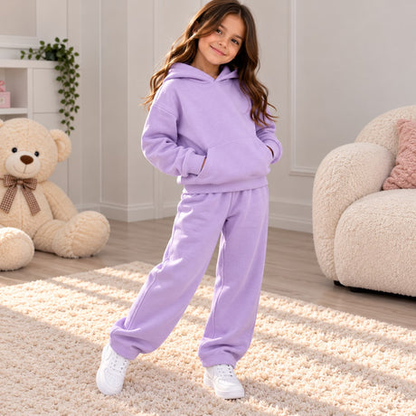 Girl in a lilac fleece hoodie and matching joggers standing on a cream rug