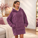 Woman in a plum purple fleece hooded blanket with a bear outline, hands in the front pocket