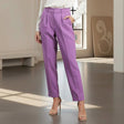 Person wearing purple pants and a white top in a room with a neutral color scheme