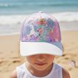 Girl wearing a lilac kids cap with a sequin unicorn, rainbow print and a white glitter brim