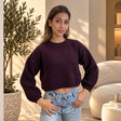 Dark plum ribbed knit cropped sweater with long sleeves, hands on hips
