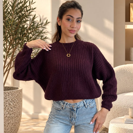 Plum purple chunky rib sweater with a gold pendant necklace and jeans