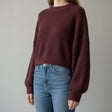 Deep plum boxy sweater in ribbed knit, slightly cropped over blue jeans