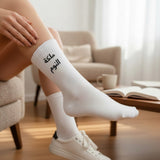 Arabic slogan socks worn with white trainers in a living room