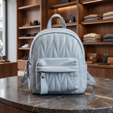Light blue quilted mini backpack with a padded front pocket