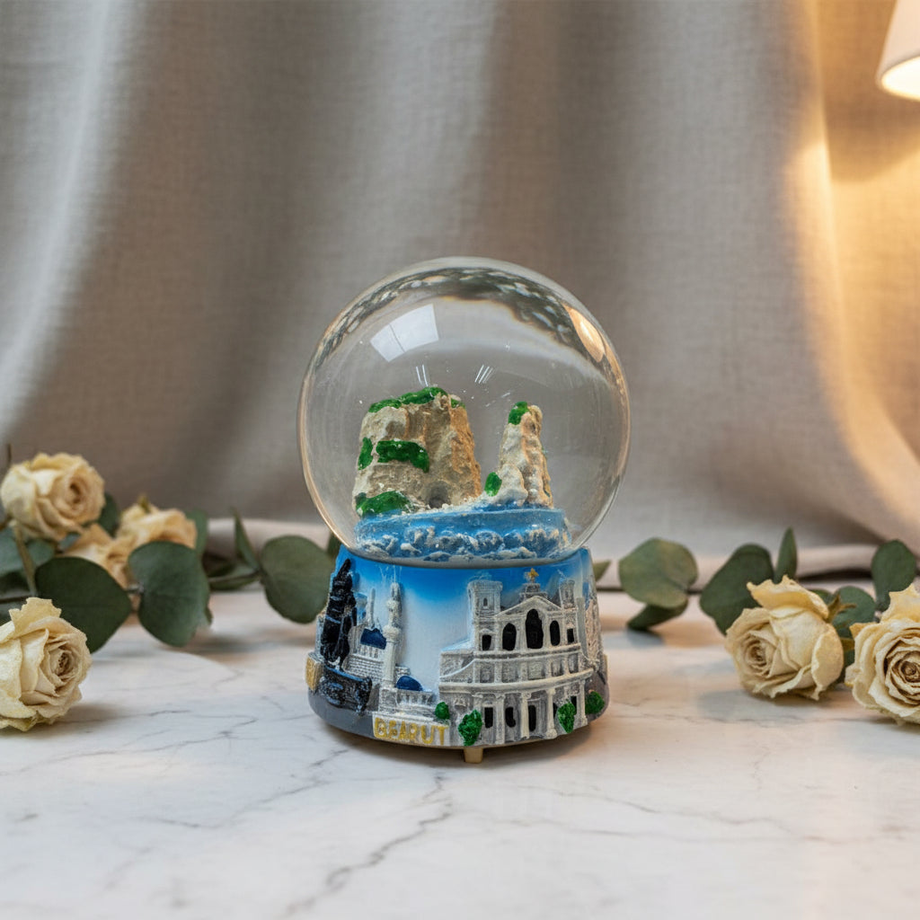 Snow globe with the Raouche Pigeon Rocks in a blue sea, on a sculpted Beirut skyline base