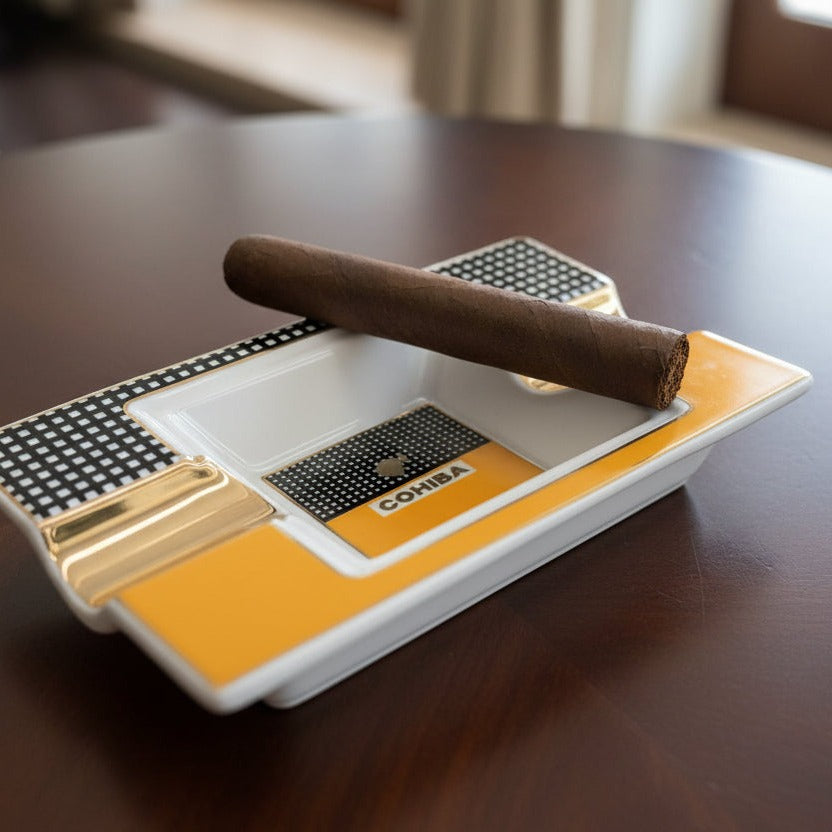 Cigar ash bowl with a single cigar on a wooden table