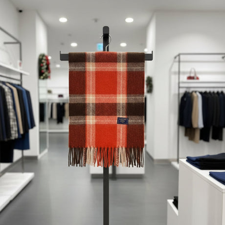 Red plaid scarf on a clothing rack in a store setting