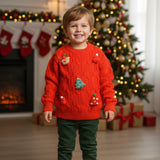 Boy wearing a red holiday knit sweater with green trousers near stockings