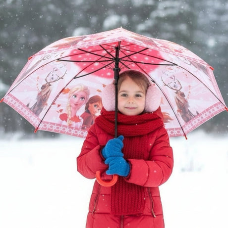 Girl in snow holding an open pink and red Frozen kids umbrella with Elsa and Anna