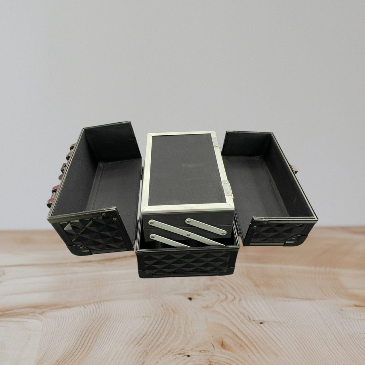 Inside of the vanity case with side trays folded out and a mirror set into the raised lid
