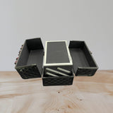 Inside of the vanity case with side trays folded out and a mirror set into the raised lid