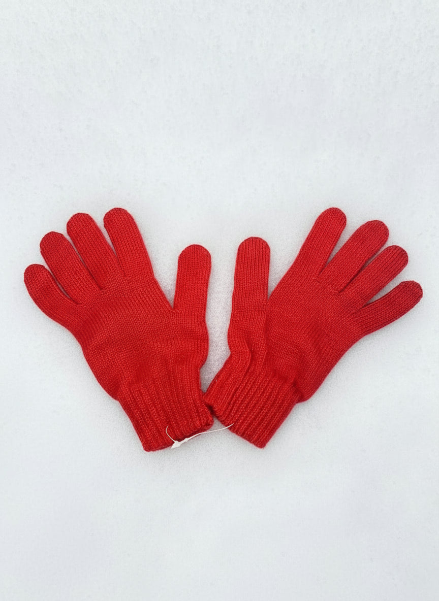 Bright red knitted gloves for kids on a snowy surface
