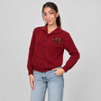 Red polo collar button cardigan with a small chest patch, worn with jeans