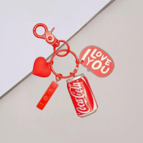 Keychain with Coca-Cola can, heart, and 'I Love You' tag on a light grey background
