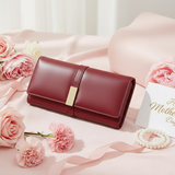 Red leather wallet with pink roses and a 'Happy Mother's Day' card on a pink surface