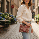 Woman carrying a red medallion tapestry bag with light jeans