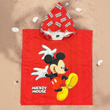 Red Mickey Mouse poncho towel with a logo patterned hood flat lay on sand