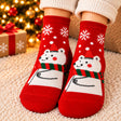 Red Christmas socks with white snowflakes and a polar bear wearing a red hat and striped scarf