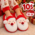 Bright red kids slippers with fluffy white Santa beards and pom pom noses beside wrapped gifts