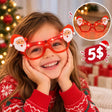 Girl resting her chin in her hands wearing glowing red novelty glasses with a Santa face on each side