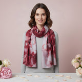 Woman wearing a red and white patterned scarf on a light pink background