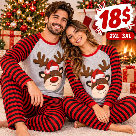 Smiling couple in matching reindeer Christmas pyjamas with red and black striped sleeves and pants by a fireplace