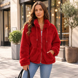 Woman in a zipped red teddy fleece jacket with red drawstrings and light blue jeans