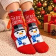 Red Merry Christmas socks with a top hat snowman, grey pom poms and orange plush arms