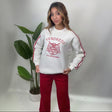 White sweatshirt with a red tiger crest varsity print, red sleeve stripes and red wide leg pants