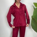 Close up of a deep red velvet pajama shirt with notch collar and button front