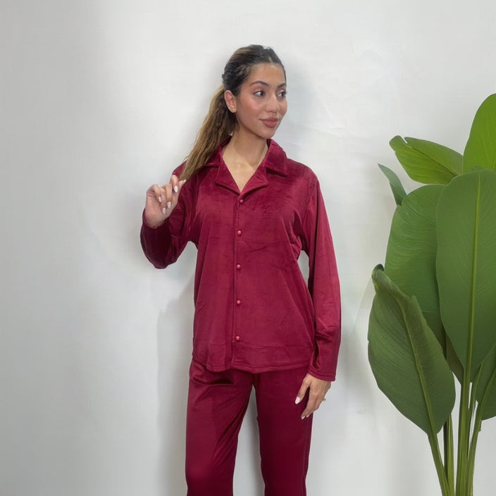 Woman in a red velvet button up PJ set with a collared long sleeve shirt and matching pants