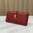 Red wallet with a gold clasp on a white surface with a beige background