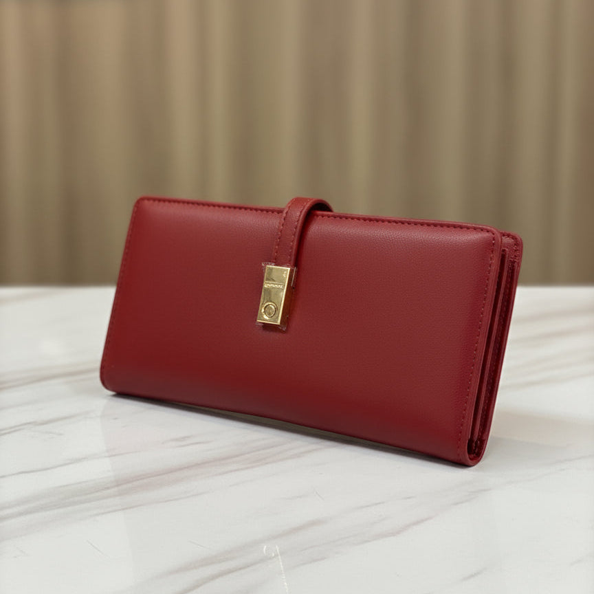 Red wallet with a gold clasp on a white surface with a beige background