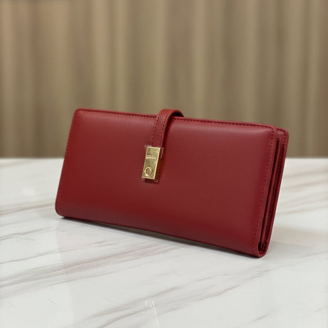 Red wallet with a gold clasp on a white surface with a beige background