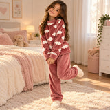 Girl standing on one leg in a rose cloud print fleece pyjama top and matching trousers