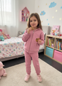 Girl in a rose pink zip up hoodie and matching joggers