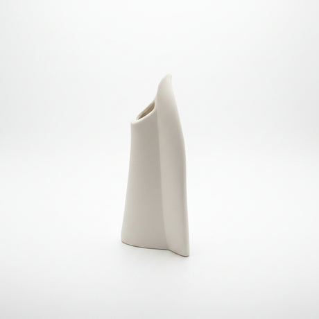 Edge on studio view of the disc vase, a narrow curved slab with an angled oval mouth