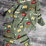 Sage green car print pajama top and pants laid flat on a grey wooden floor