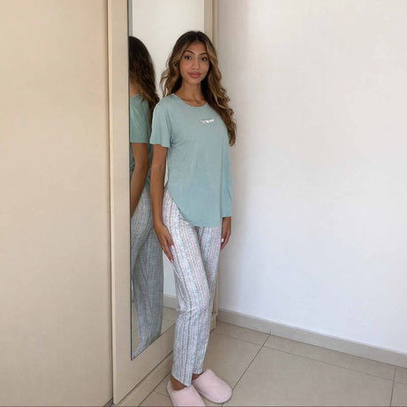 Side view of pale stripe trousers worn with a green short sleeve pyjama top