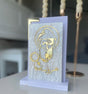 Hooded bearded saint in gold outline with a halo, Arabic script and a small rosary