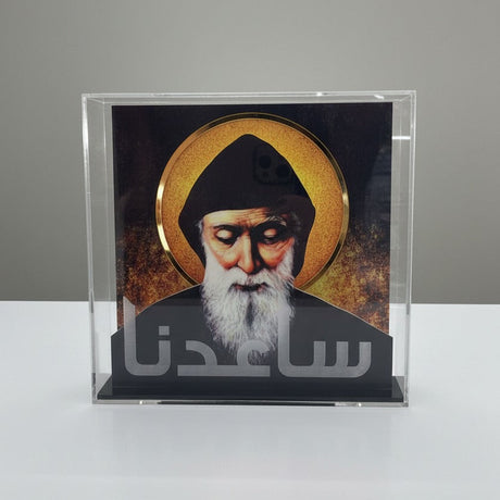 The hooded saint painted against burnt amber above a black base with etched Arabic