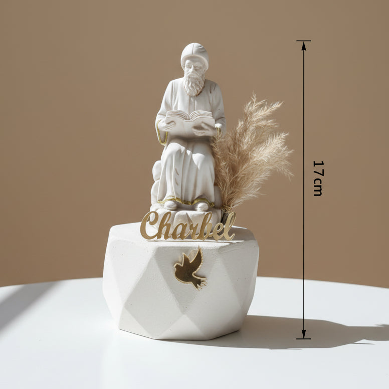 White resin monk with gold hem and belt on a faceted base with a gold dove, marked 17cm