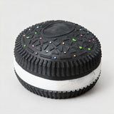 Black sandwich cookie squishy with white cream filling and tiny sprinkle dots