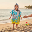 Boy wearing a grey shark poncho towel with a shark head hood and teeth across the chest