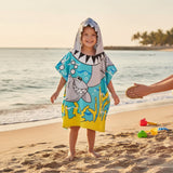 Boy wearing a grey shark poncho towel with a shark head hood and teeth across the chest