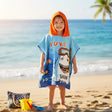 Boy wearing a blue shark poncho towel with a bright orange hood on the beach