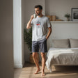 Shark print pyjama set worn holding a mug in a calm bedroom