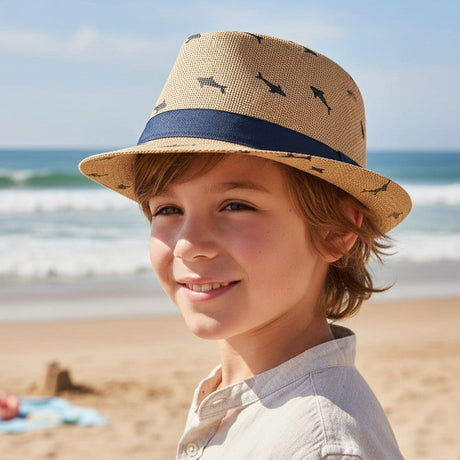 Smiling child in a light brown straw fedora with navy sharks and a wide navy band