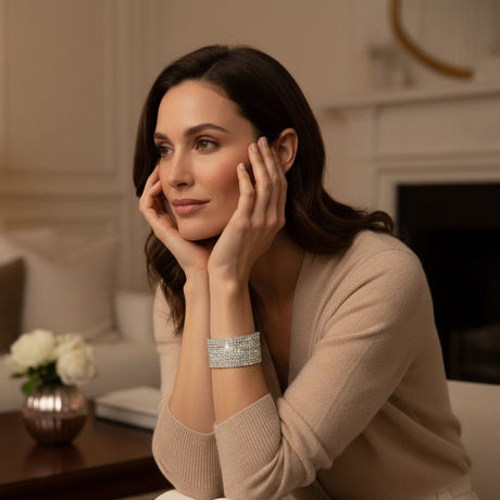 Woman wearing a shiny silver bracelet in a cozy indoor setting